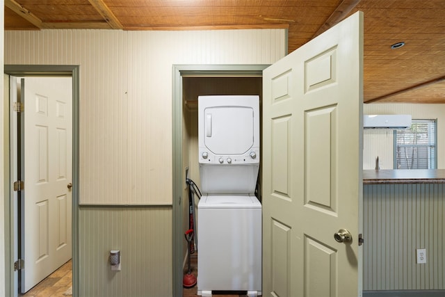 washroom featuring laundry area, an AC wall unit, wooden ceiling, and stacked washer / drying machine