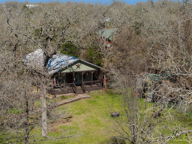 view of yard featuring a porch and a forest view