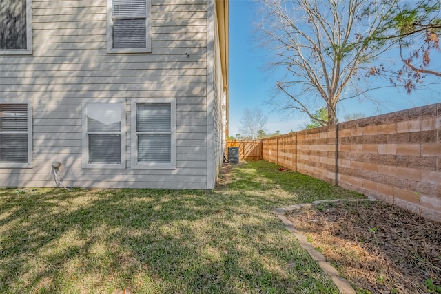 exterior space with a fenced backyard and a lawn