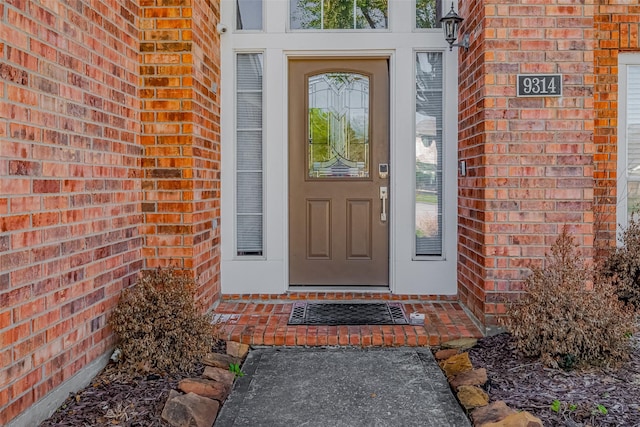 property entrance featuring brick siding