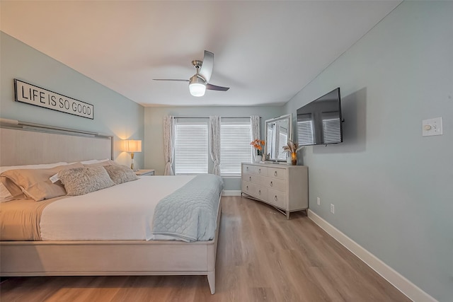 bedroom with wood finished floors, a ceiling fan, and baseboards