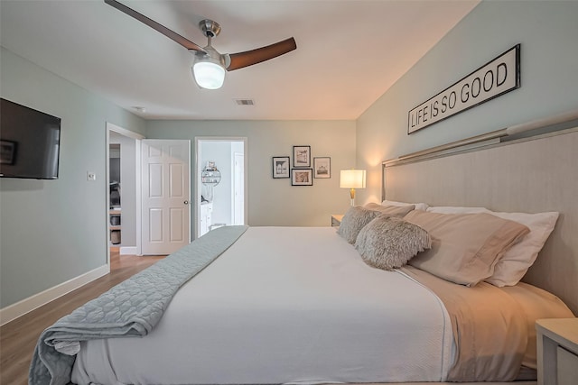 bedroom featuring a ceiling fan, visible vents, baseboards, and wood finished floors