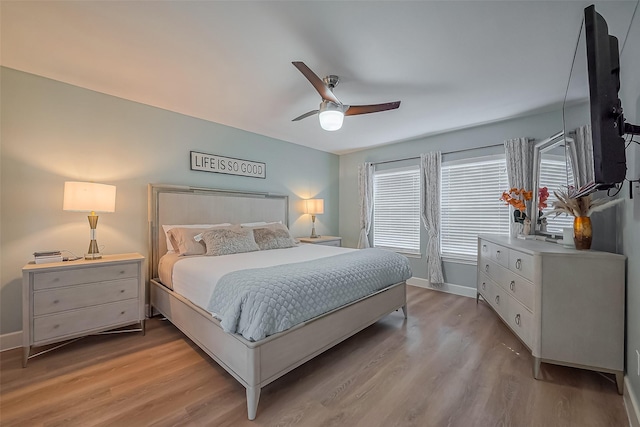 bedroom featuring light wood-style floors, baseboards, and a ceiling fan