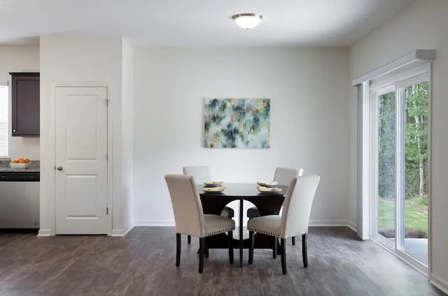 dining area featuring dark wood-style flooring and baseboards