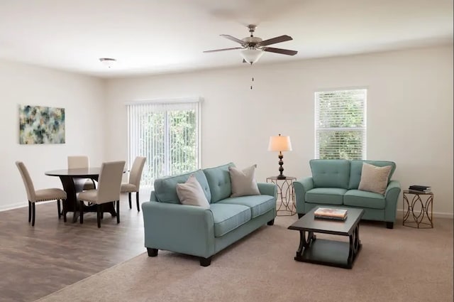 living area featuring baseboards and a ceiling fan