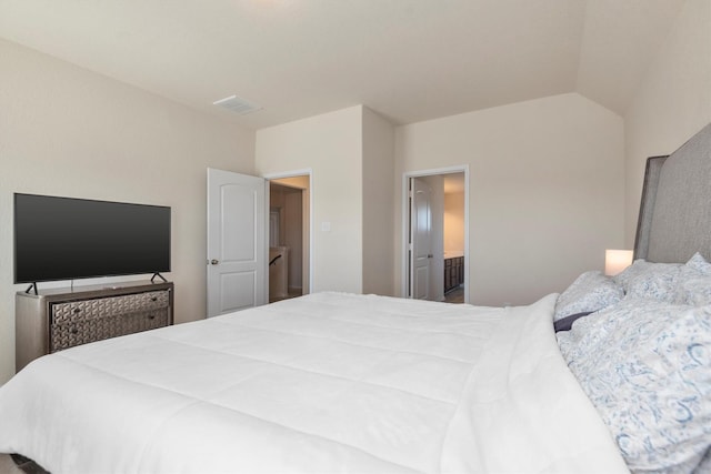 bedroom featuring lofted ceiling, visible vents, and connected bathroom