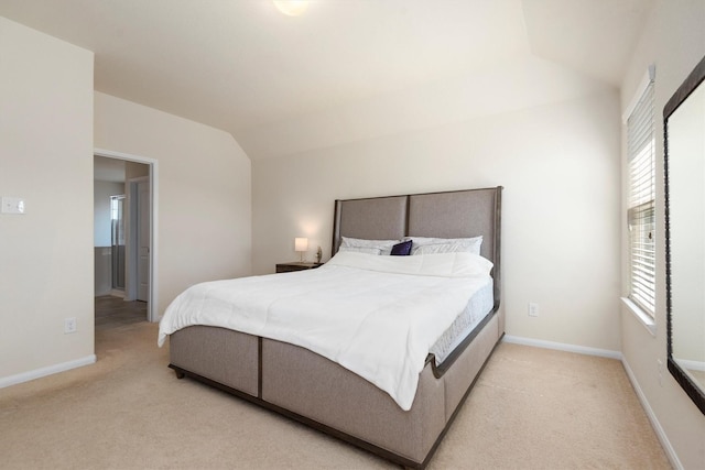 bedroom with lofted ceiling, light carpet, and baseboards