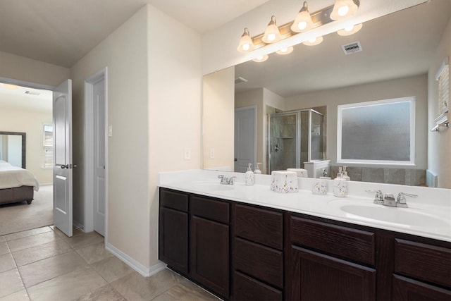 bathroom featuring double vanity, a stall shower, visible vents, tile patterned flooring, and a sink