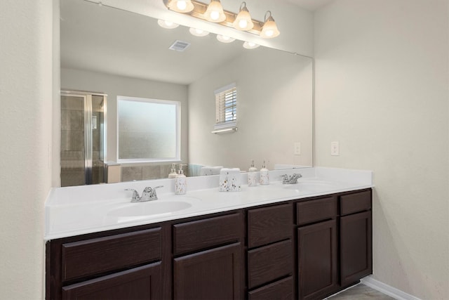 full bathroom with a stall shower, visible vents, a sink, and double vanity