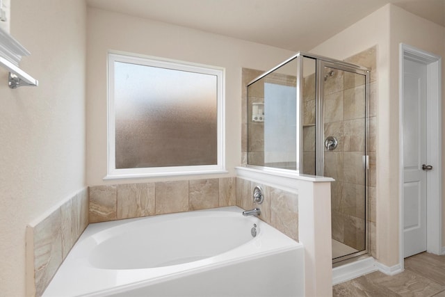 bathroom featuring a garden tub and a shower stall