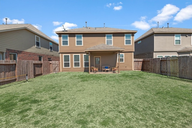 rear view of house with a fenced backyard, a lawn, and a patio