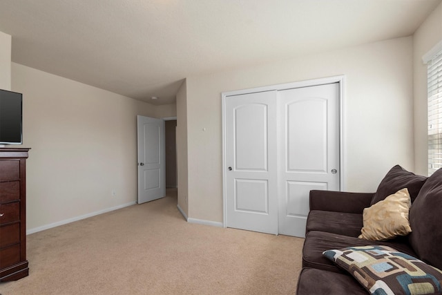 living area featuring light carpet and baseboards