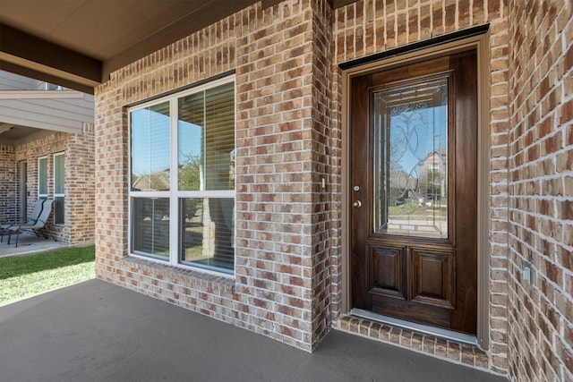 doorway to property featuring brick siding