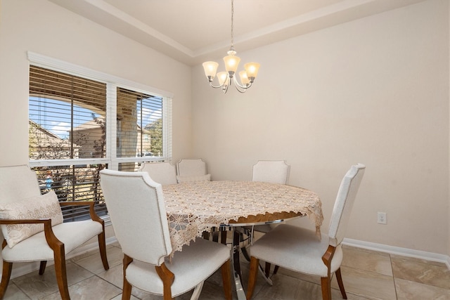 dining space with a raised ceiling, a notable chandelier, baseboards, and light tile patterned floors