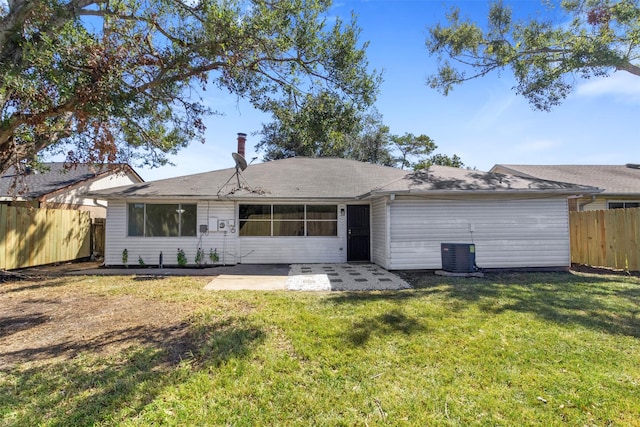 rear view of house with central air condition unit, a patio area, fence, and a lawn