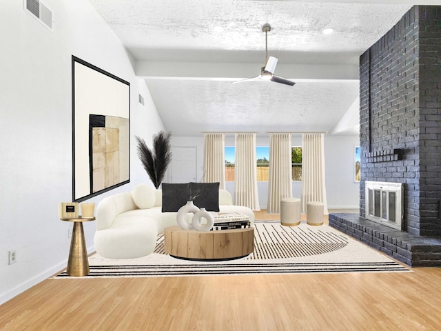 living room featuring vaulted ceiling with beams, a textured ceiling, and wood finished floors