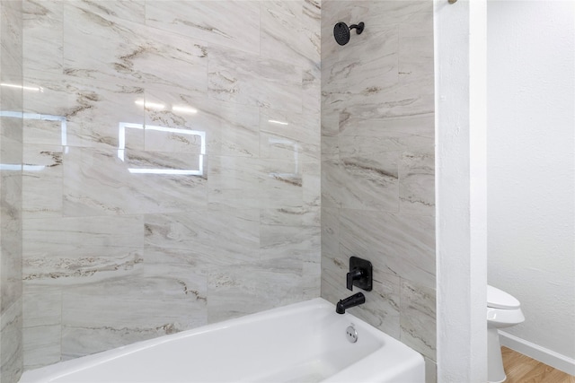 full bathroom with shower / bathtub combination, wood finished floors, toilet, and baseboards