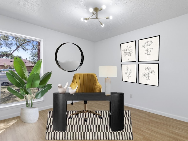 home office featuring a textured ceiling, a notable chandelier, wood finished floors, and baseboards