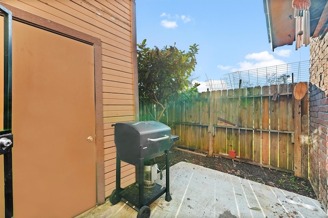 view of patio / terrace featuring a grill and fence