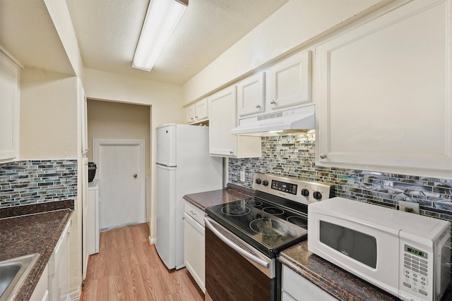 kitchen with white appliances, tasteful backsplash, white cabinets, light wood-style flooring, and under cabinet range hood