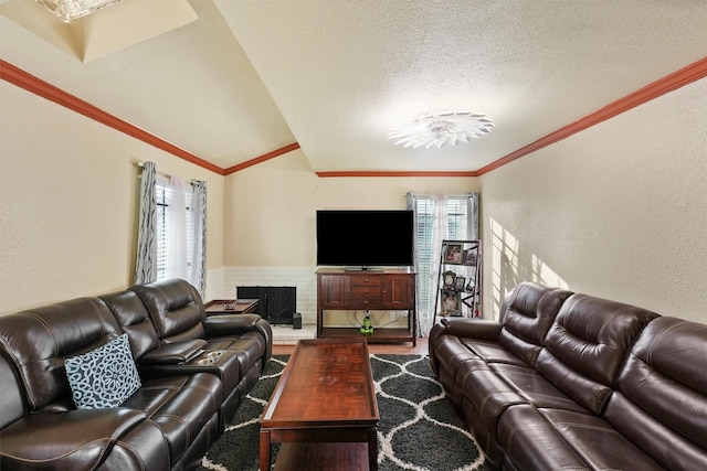 living area featuring a textured ceiling, a textured wall, ornamental molding, and vaulted ceiling