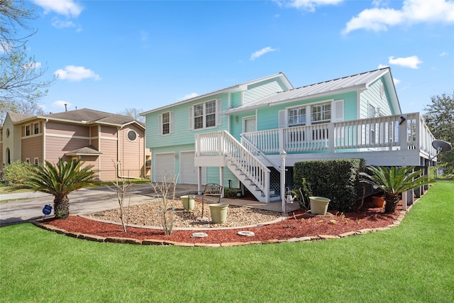 view of front facade with metal roof, an attached garage, concrete driveway, stairway, and a front lawn