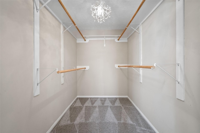 spacious closet with carpet and a notable chandelier