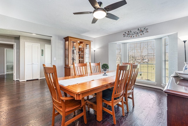 dining space with ceiling fan, a textured ceiling, baseboards, and wood finished floors