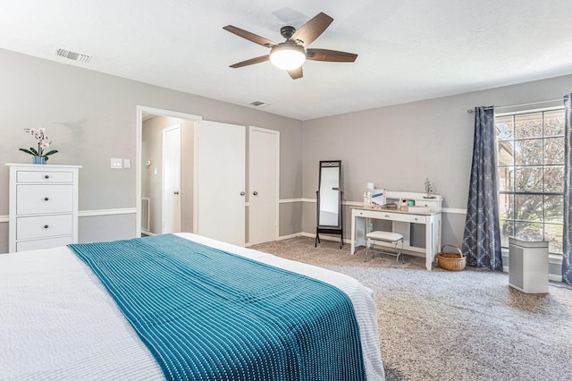 carpeted bedroom featuring visible vents, baseboards, a textured ceiling, and a ceiling fan