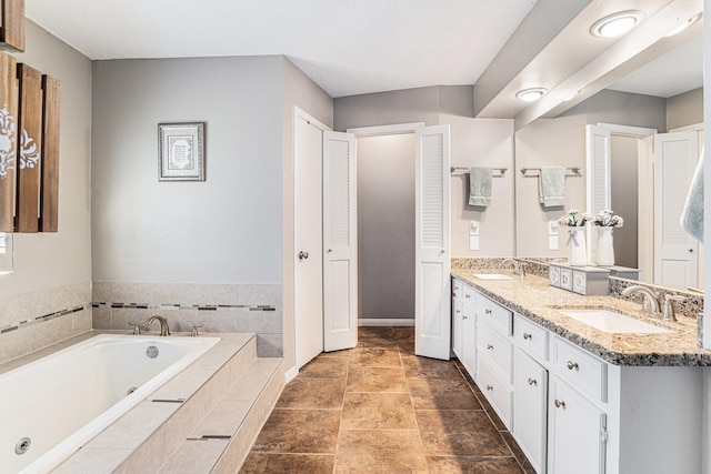 full bathroom with double vanity, a whirlpool tub, and a sink