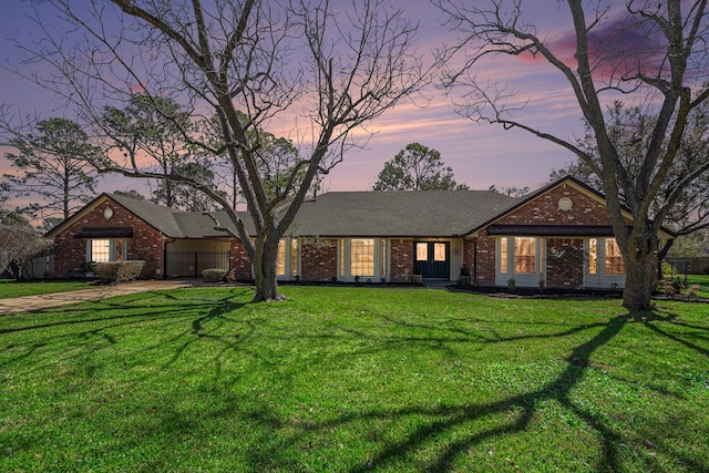 ranch-style house with a yard and brick siding