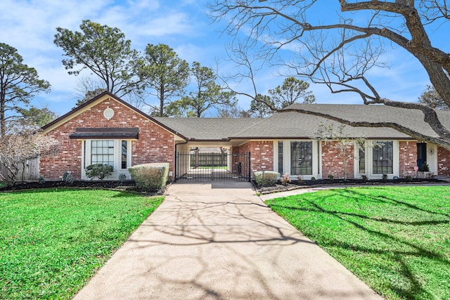 single story home with fence, brick siding, a front lawn, and a gate