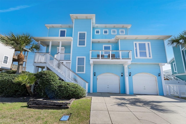 coastal home with driveway, an attached garage, and stairs