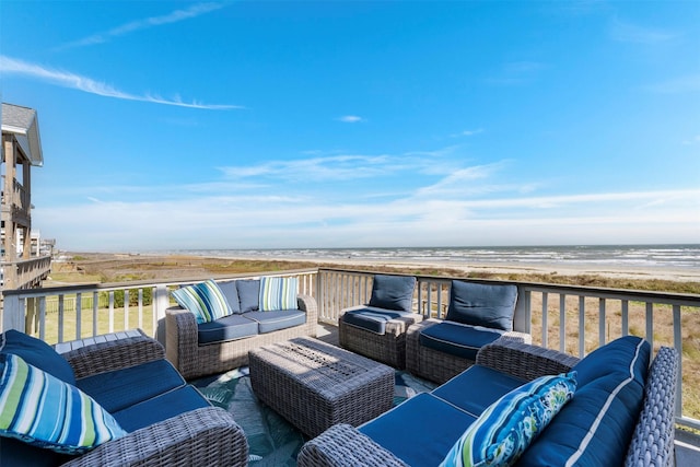 deck with a water view, an outdoor living space, and a view of the beach