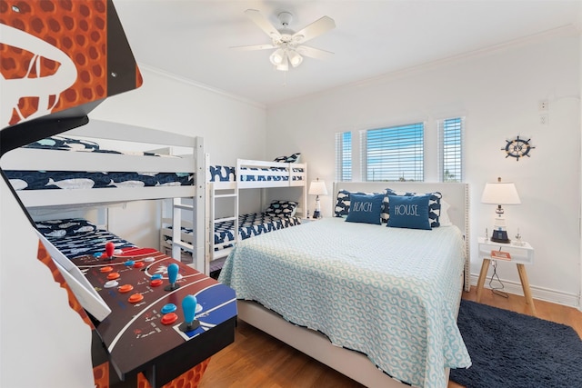 bedroom featuring ceiling fan, ornamental molding, wood finished floors, and baseboards