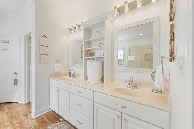 bathroom featuring double vanity, ornamental molding, a sink, and wood finished floors