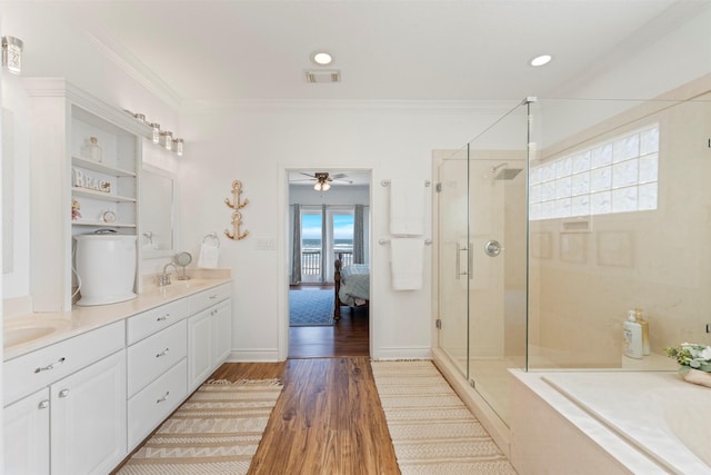 full bath with wood finished floors, visible vents, double vanity, a stall shower, and crown molding