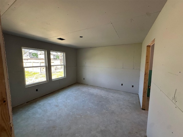 unfurnished room with visible vents and unfinished concrete floors