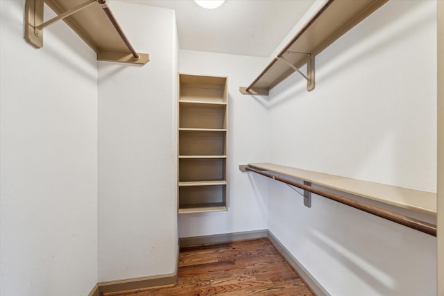 walk in closet with wood finished floors