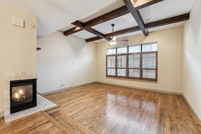 unfurnished living room with coffered ceiling, a fireplace, baseboards, and wood finished floors