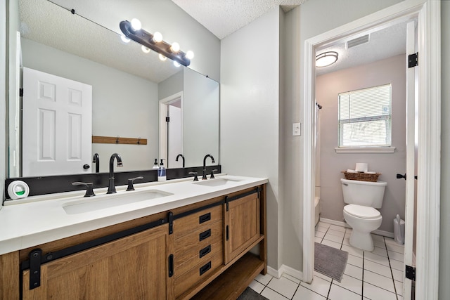 bathroom with tile patterned flooring, a textured ceiling, toilet, and a sink