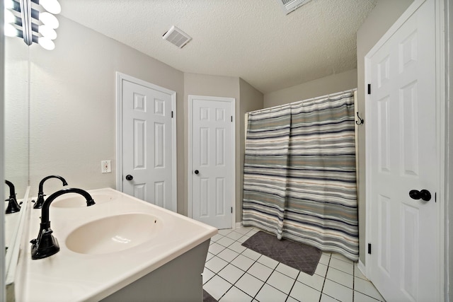 full bathroom with visible vents, a shower with shower curtain, tile patterned floors, a textured ceiling, and a sink