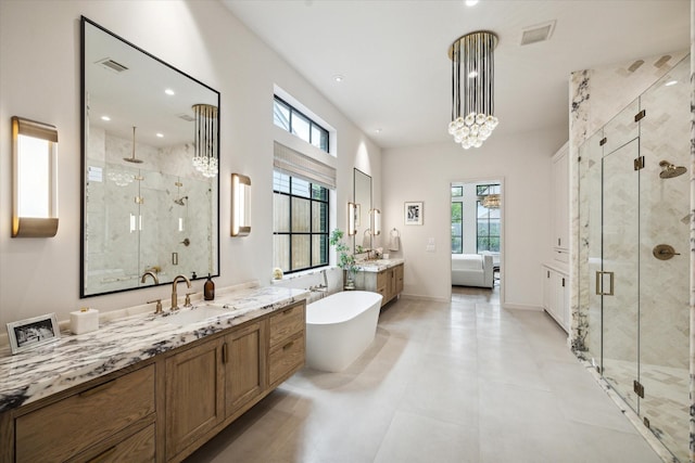 ensuite bathroom featuring a shower stall, a healthy amount of sunlight, visible vents, and a sink