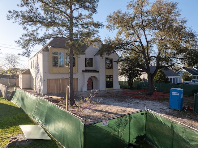 view of front of house with stucco siding and fence