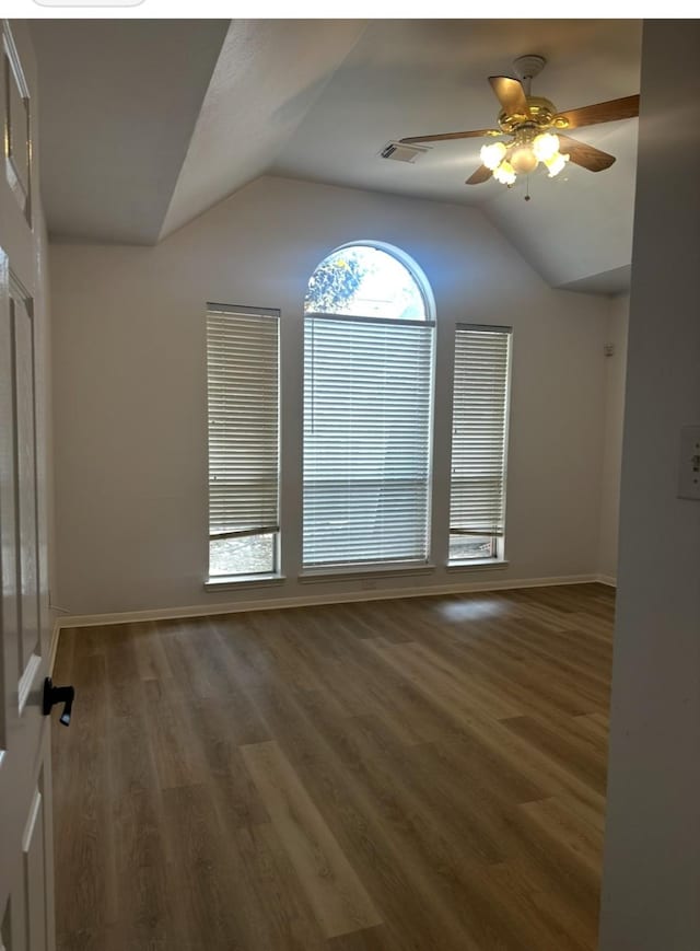 unfurnished room with lofted ceiling, ceiling fan, wood finished floors, and baseboards