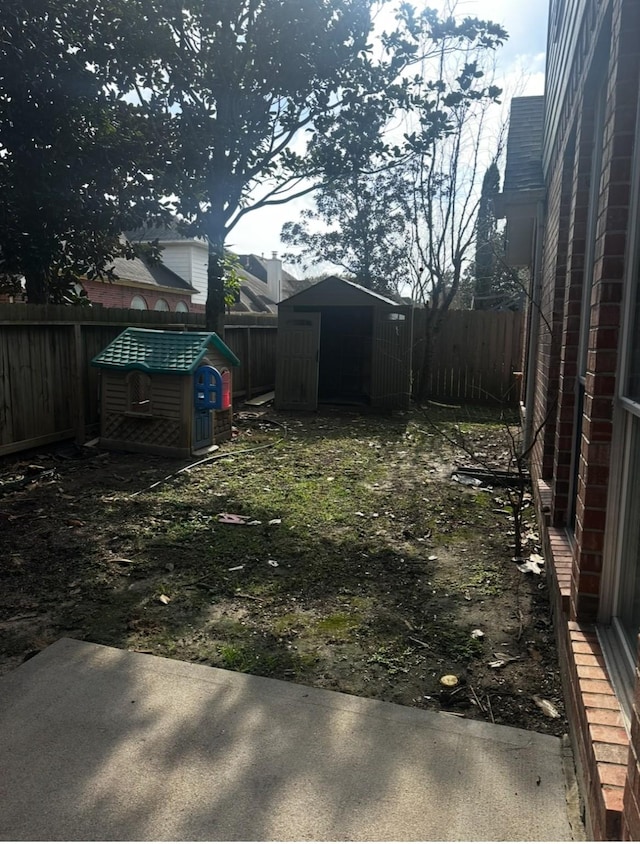 view of yard featuring an outbuilding, a storage shed, a patio area, and a fenced backyard