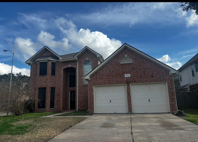 traditional home with a garage, brick siding, and driveway