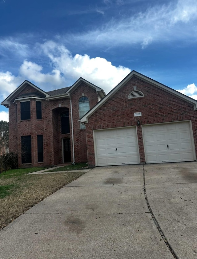 traditional-style home featuring driveway, a garage, and brick siding