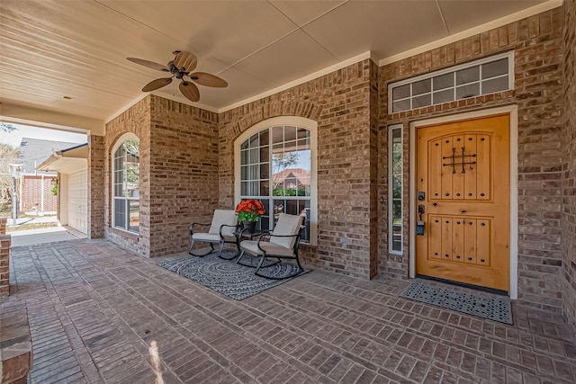 doorway to property featuring covered porch, ceiling fan, and brick siding