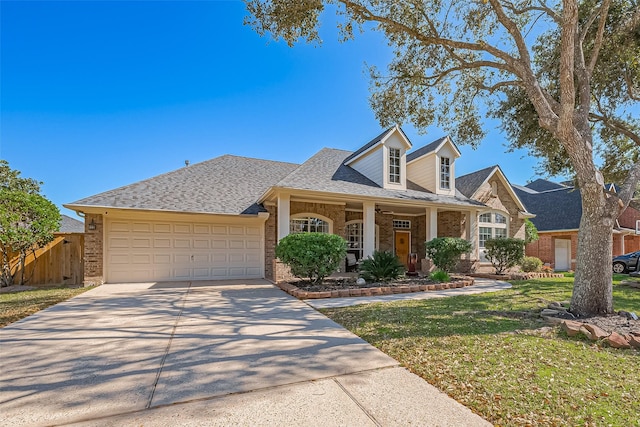 view of front of home featuring a garage, concrete driveway, fence, a front lawn, and brick siding